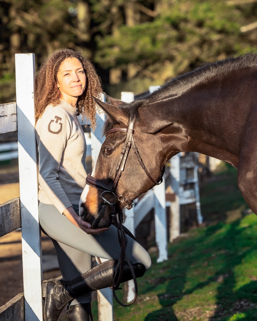 Sigourney Leigh Jellins at the barn with a bay horse